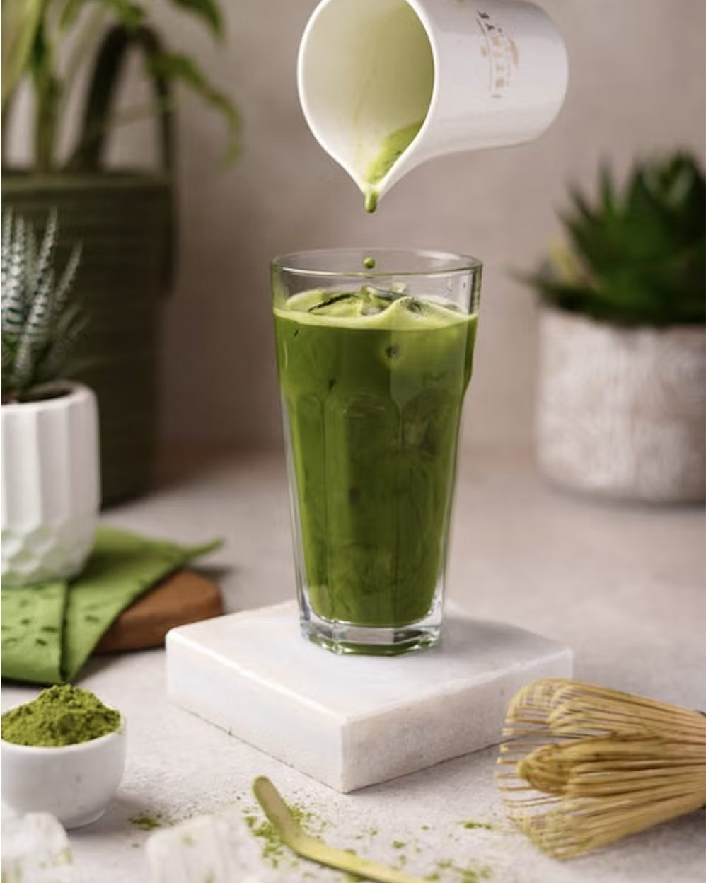An iced matcha latte being poured