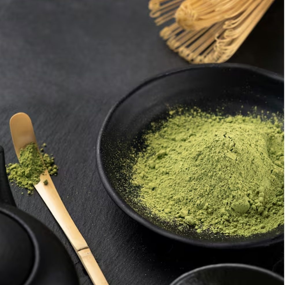 Fresh strawberries, matcha powder and a whisk on the counter