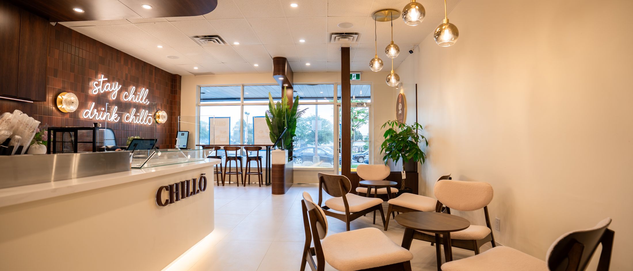 The room at Chillō café — 'stay chill, drink chillō' neon, the counter and seating in Castledean Plaza, Kanata